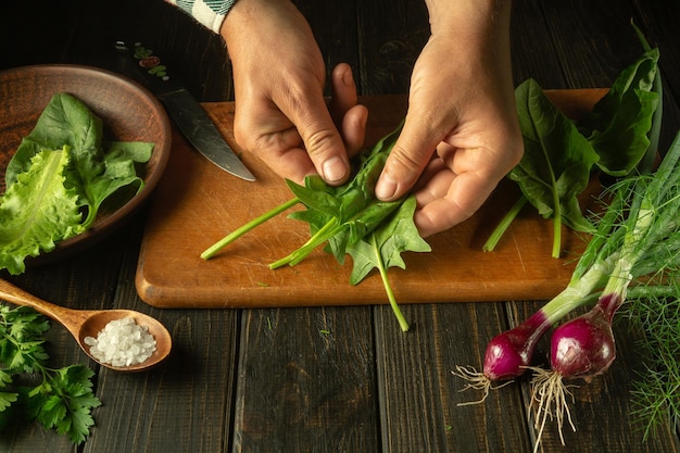 Zbliżenie na dłonie krojące zioła